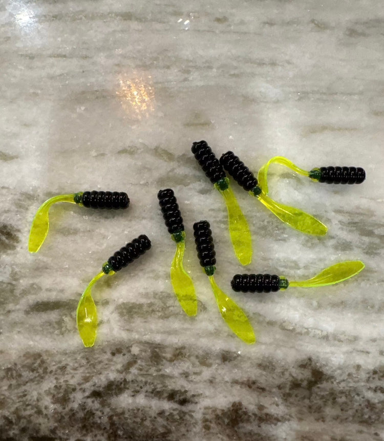 Group of soft plastic Crappie Jigs 2” long with a black head and a shiny chartreuse flat Beaver like tail