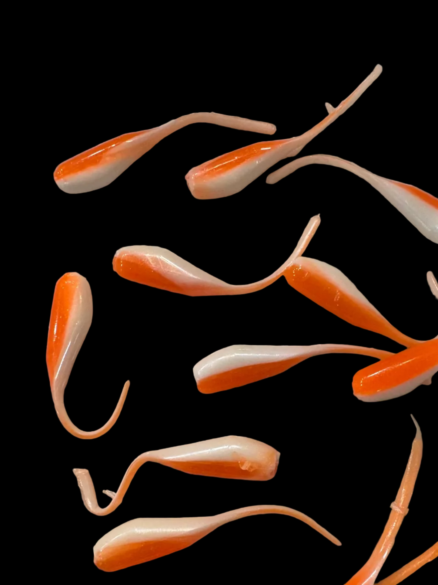 Minnow shaped soft plastic crappie jigs in two colors. Shiny orange top with a frosty white under belly