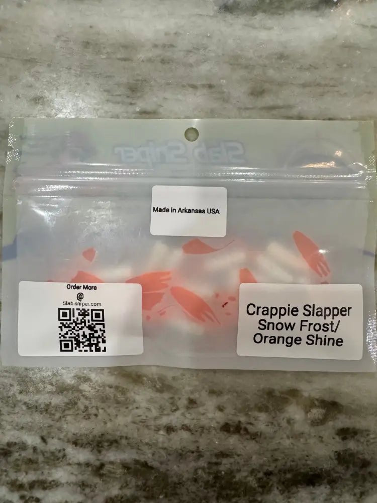Back view of a package of Slab Sniper Crappie Jigs with stickers showing made in Arkansas style of jig and color and QR code