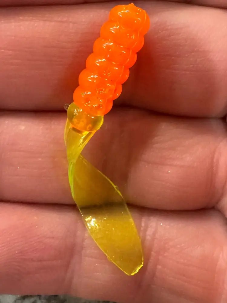Soft plastic Crappie jig with a tangerine orange head and translucent chartreuse flat beaver tail