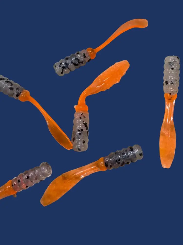 Soft plastic Crappie jig 2 inches long with a clear translucent head with black glitter and shiny orange flat beaver tail