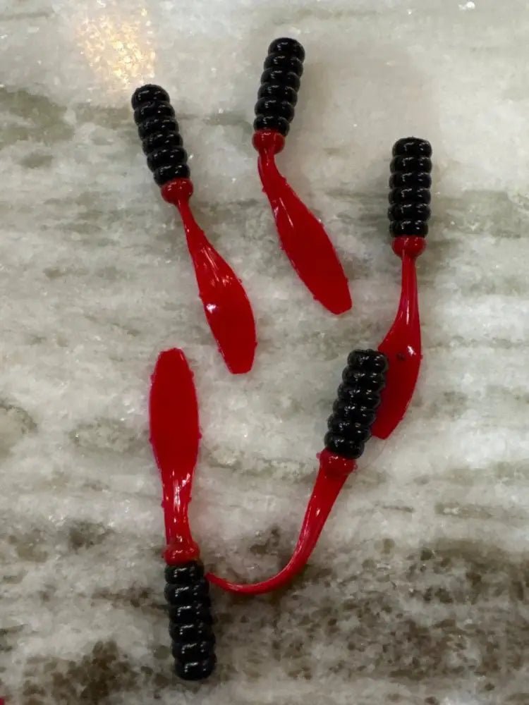 Soft plastic Crappie jig 2 inches long with a black head and translucent cherry red flat beaver tail