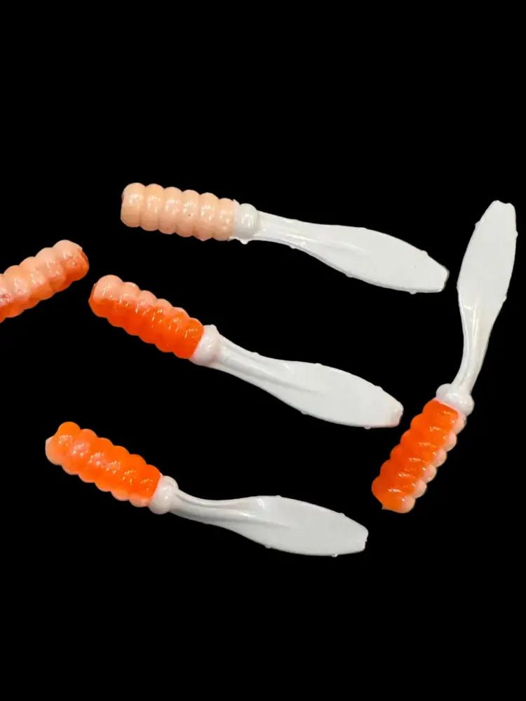 Soft plastic Crappie jigs 2 inches long with a orange white head and pearl white flat beaver tail