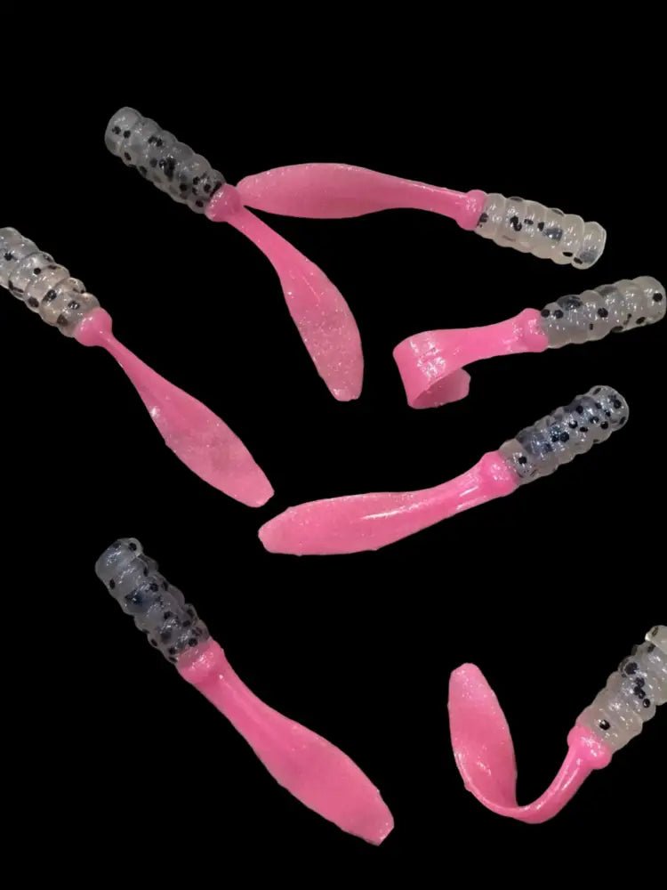 Soft plastic Crappie jigs 2 inches long with a clear translucent head with black glitter and a pearl pink flat beaver tail.
