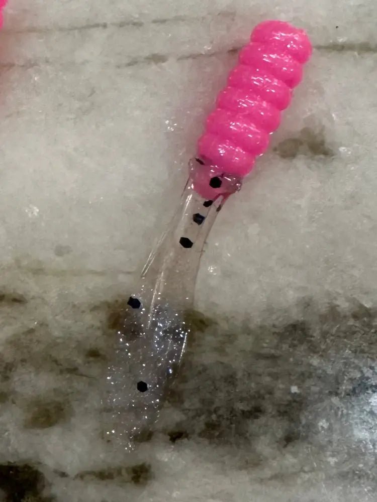 Soft plastic Crappie jigs 2 inches long with a pink head and translucent  clear flat beaver tail with black glitter